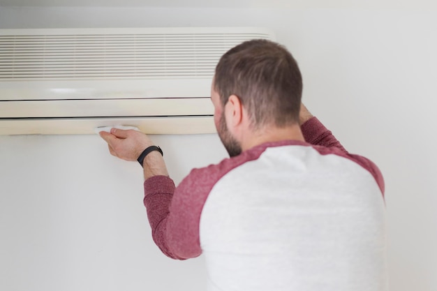 caucasian-man-cleaning-air-conditioner_255880-2972